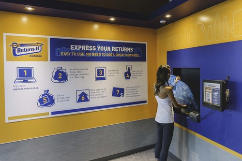 Individual placing a full bag of recyclable beverage containers to eh Express Returns service window